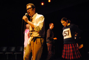 Jonathan Miot as William Barfee (at the microphone) 