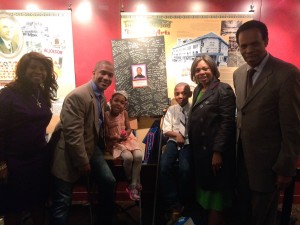 Evan Alston (to the right of the poster) and family celebrate Alston's success as a young playwright