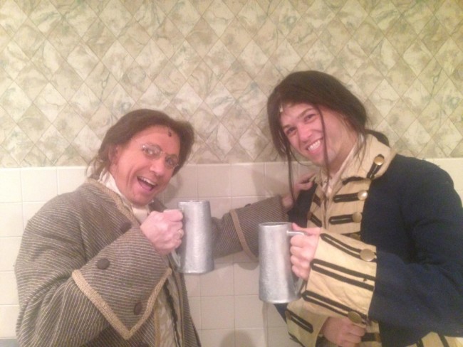 Andrew McNair (L- David James) and the Courier (R- Matthew Hirsh) share a pint of rum while congress is out before the Courier returns to the battlefield