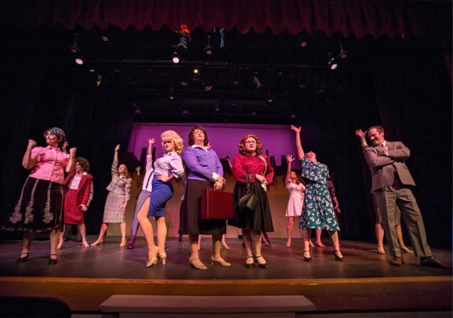 At center are  Doralee (Lucy Bobbin, r), Violet (Robyn Bloom, c), and Judy (Caitlin Grant, l)   surrounded by the office staff. Mr. Hart (Richard Greenslit) stands at the right.