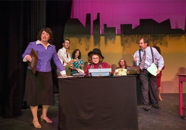 Violet (Robyn Bloom, l) tests the typing skills of new hire Judy (Caitlin Grant, seated).