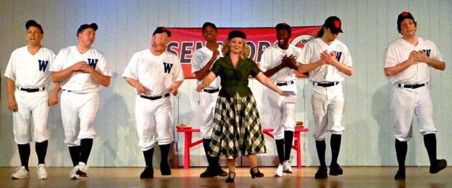 Ashley Gerhardt (center) as Reporter Gloria Thorpe and the Baseball Ensemble of Damn Yankees at The Heritage Players