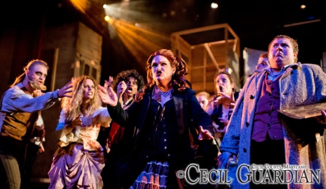Lauren Spencer-Harris (center) as Mrs. Lovett and Zack Lockwood (right) as Tobias with the ensemble of Sweeney Todd