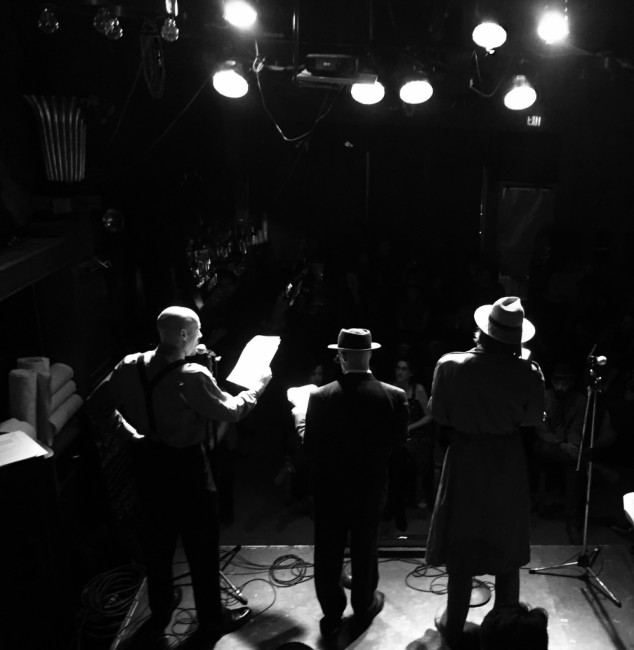 Jon Higgins (left) Craig Coletta (center) and Jeffrey L. Gangwisch (right) performing in the monthly live radio-play broadcast of Horatio Dark's Between the Lines at Yellow Sign Theatre