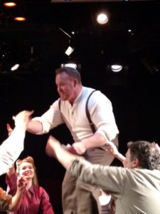 A tech-week rehearsal photo of Rob Wall (center) as Ché in Evita at Spotlighters Theatre