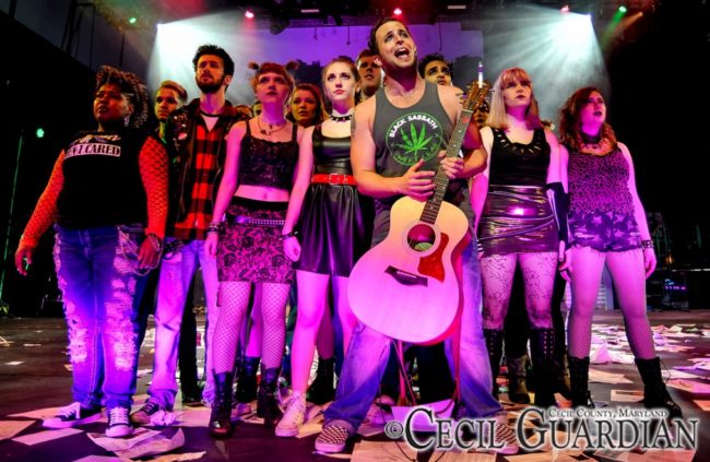 Brendan Sheehan (center) as Johnny and the ensemble of American Idiot at Milburn Stone Theatre