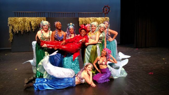 Brandon Shaw (center) as Sebastian and the Mersisters of Charm City Player's The Little Mermaid