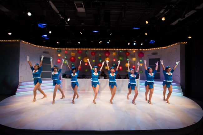 (L-R) Corinne Holland, Mackenzie Newbury, Patricia "Pep" Targete, Carolyn Burke, Hannah Jennens, Alexis Kray, Melrose Pyne, and Ariana Kruszewski as Frank Abagnale Jr. Dancers in Catch Me If You Can at NextStop Theatre