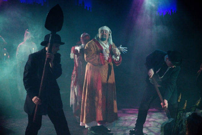 David Bosley-Reynolds (center) as Ebenezer Scrooge and the company of A Christmas Carol