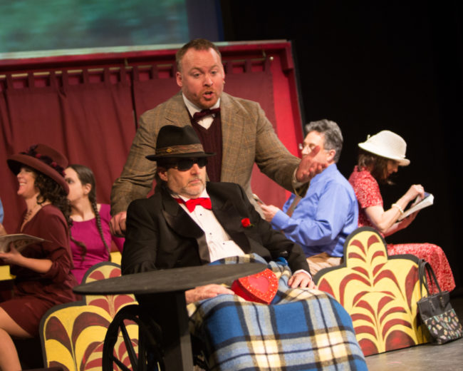 Rob Wall (center) as Harry Witherspoon with Michael Cornell (in the wheelchair) as Tony Hendon in Lucky Stiff