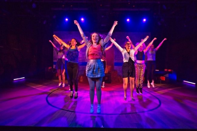 Hailey Ibberson (center) as Lysistrata Jones with her gang of cheerleaders