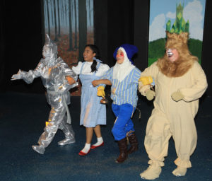 (L to R) Marie Nearing as The Tin Man, Loraine Hamlett as Dorothy, Sarah Dallas DeFord as Scarecrow, and Stephen P. Yednock as Cowardly Lion