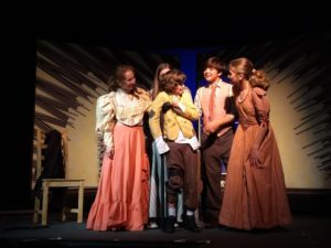 Marshall L. Naylor (center) as Tiny Tim with the four Cratchit Children around him