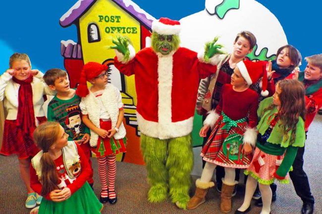 Jim Rose (center) as The Grinch, surrounded by the Whos of Whoville