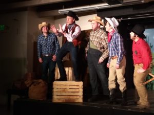 Joe Weinhofer (center) as Will Parker with the male ensemble in Oklahoma!