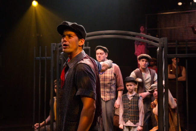 Matt Hirsch (center) as Jack Kelly with the Newsies singing "Seize The Day" in Newsies at Toby's Dinner Theatre