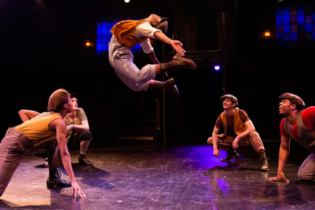 Gregory Banks (center) as Specs in Newsies at Toby's Dinner Theatre