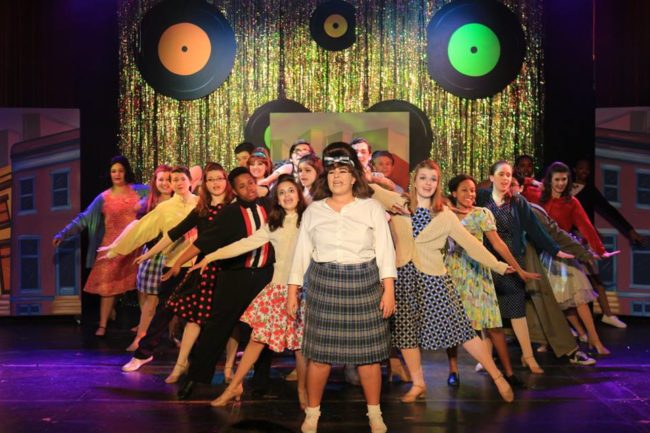 Valerie Ziegler (center) as Tracy Turnblad andthe ensemble of Hairspray at Children's Playhouse of Maryland