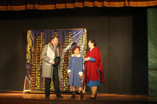 Doug Kotula (left) as Oliver Warbucks, Mia Novak (center) as Annie, and Lauren DeSha (right) as Grace Farrell