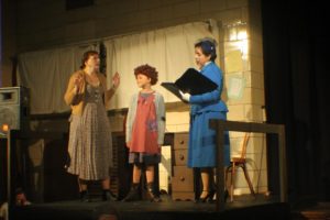 Heidi Toll (left) as Miss Hannigan, Mia Novak (center) as Annie and Lauren DeSha (right) as Grace Farrell