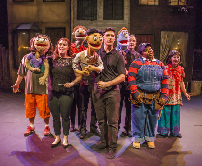 Josh Scoff (center) as Princeton with the Company of Avenue Q at Cockpit in Court