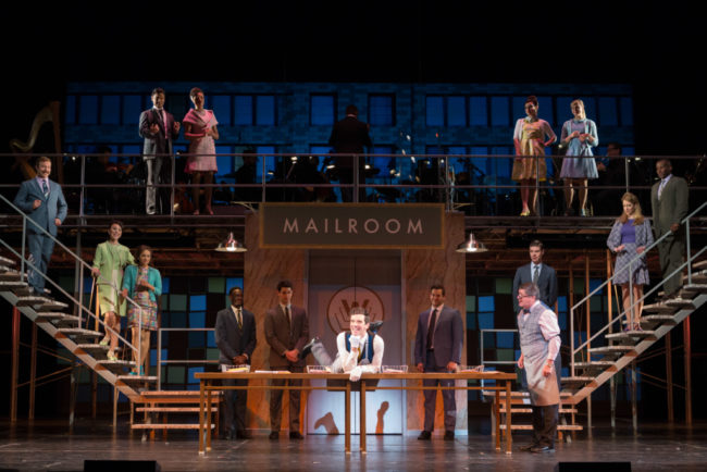 Michael Urie (center) as Bud Frump and the company of How to Succeed in Business Without Really Trying
