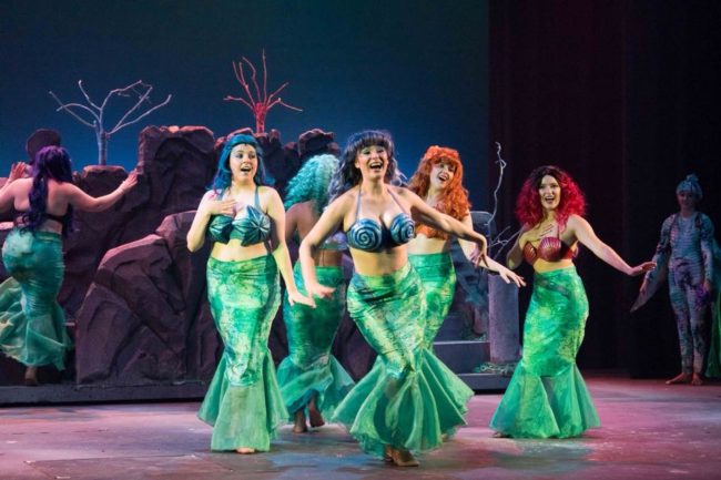 Malarie Zeeks (center) as Arista and The Mersisters (surrounding) Ellen Manuel as Aquata, Elisabeth Johnson as Andrina, Kaitlyn Jones as Atina, Emily Caplan as Adella, and Hannah Bartlett as Allana in The Little Mermaid