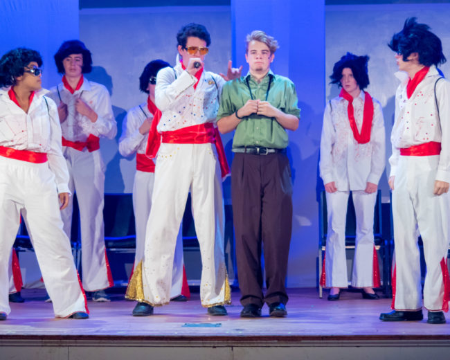 Henry O'Toole (center left) as Roy Bacon and Nick Zuelsdorf (center right) as Jack Singer and the ensemble of Honeymoon in Vegas