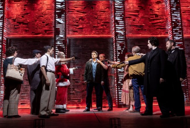 Sam Ludwig (center) as the Balladeer and the cast of Assassins at Signature Theatre. Photo: Christopher Mueller