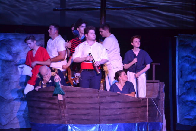 Nicholas Cloutier (center) as Prince Eric and the crew of his ship in The Little Mermaid