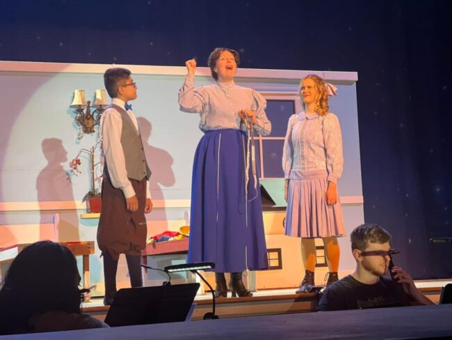 Elijah Tsakalos (left) as Michael Banks, with Katie Sheldon (center) as Mary Poppins, and Bella Comotto (right) as Jane Banks. 📷Lauren Spencer-Harris  & Kristin Rigsby