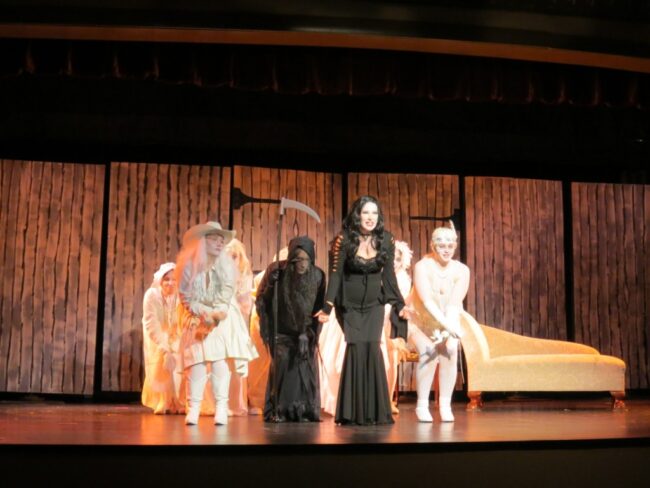 Michele Guyton (center) as Morticia and the Ancestors in The Addams Family. 📷 Cathy Herlinger