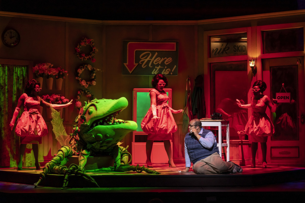 Derrick D. Truby Jr. (Seymour) with Kaiyla Gross (Ronnette), Nia Savoy-Dock (Chiffon) and Kanysha Williams (Crystal), in the 2024 Ford’s Theatre production of Little Shop of Horrors 📷 Scott Suchman