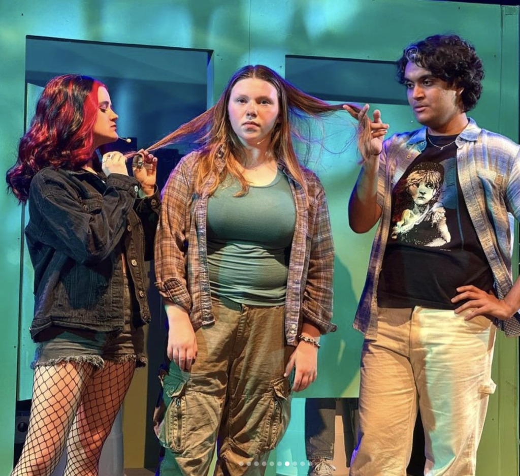Bella Comotto (left) as Janis Sarkisian, with Reese Bruning (center) as Cady Heron, and Shahmeer Mirza (right) as Damian Hubbard in Mean Girls (High School Edition) at Children's Playhouse of Maryland.