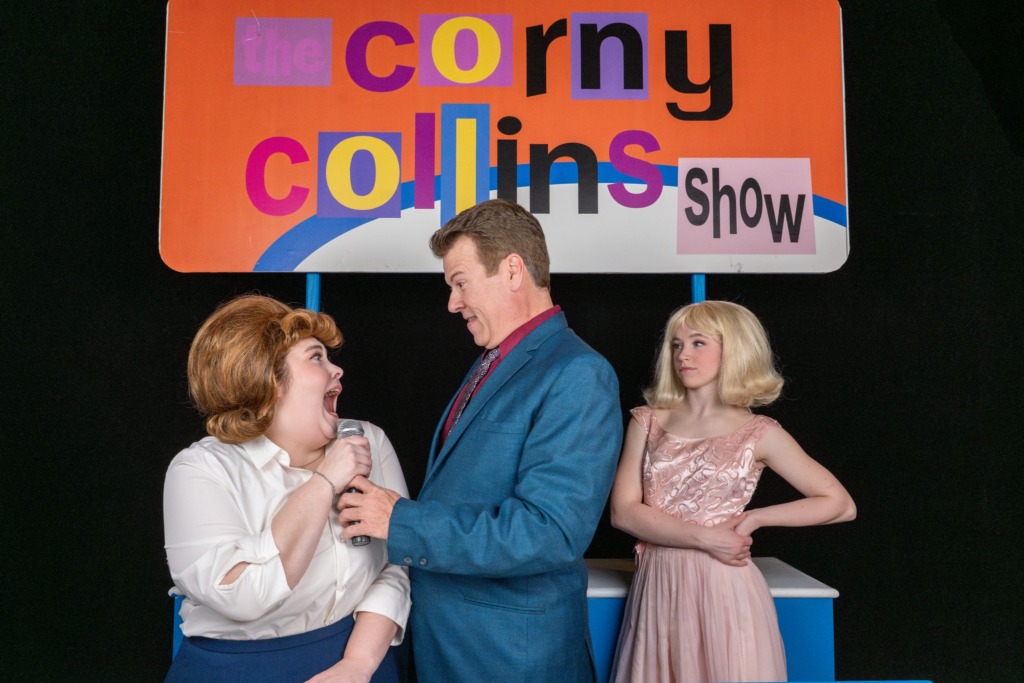 Megan Smith (left) as Tracy with Joey Hellman (center) as Corny Collins and Katelyn O'Connor (right) as Amber in Hairspray at Dundalk Community Theatre 📷 THSquared Photography