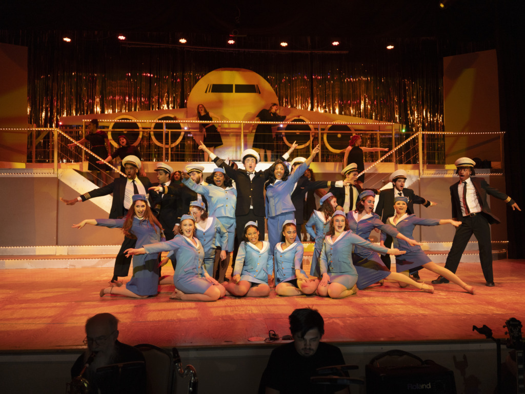 Michael Simpson (center) as Frank Abagnale Jr. and the cast of Catch Me If You Can at Suburban Players 📷 Austin Barnes