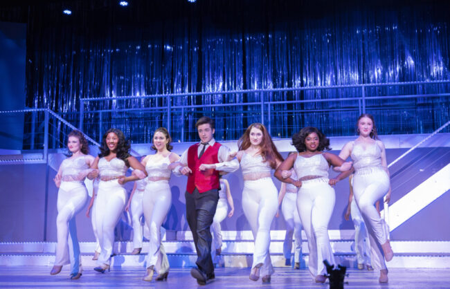 Michael Simpson (center) as Frank Abagnale Jr. and the cast of Catch Me If You Can at Suburban Players 📷 Austin Barnes