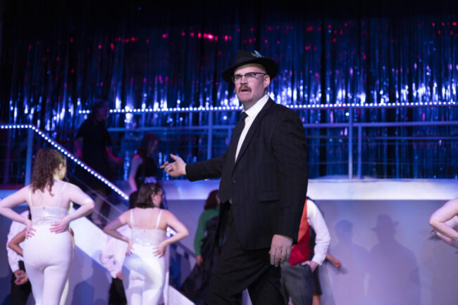 Jake Stuart (center) as Carl Hanratty and the cast of Catch Me If You Can at Suburban Players 📷 Austin Barnes