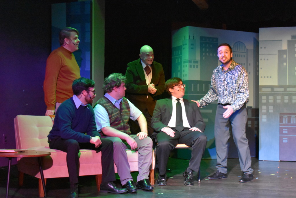 The Husbands and Bobby (Ethan Kahwaty, seated in the chair) of Company at Damascus Theatre Company 📷 Elli Swink